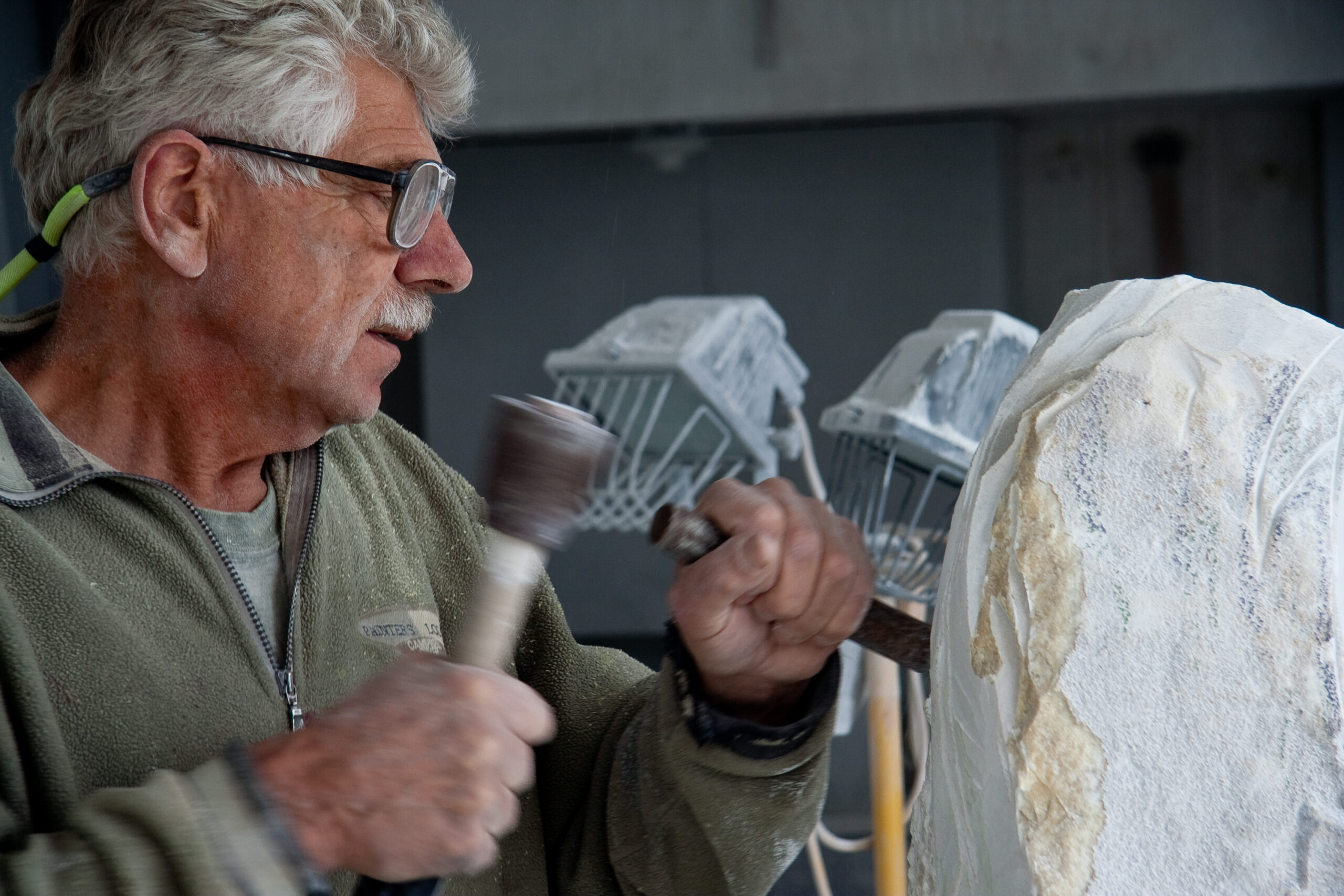 Maarten Schaddelee sculpting a large piece of marble in the gallery, visit the fine art gallery in Saanich. Seeing is believing. Touching is transforming. 
